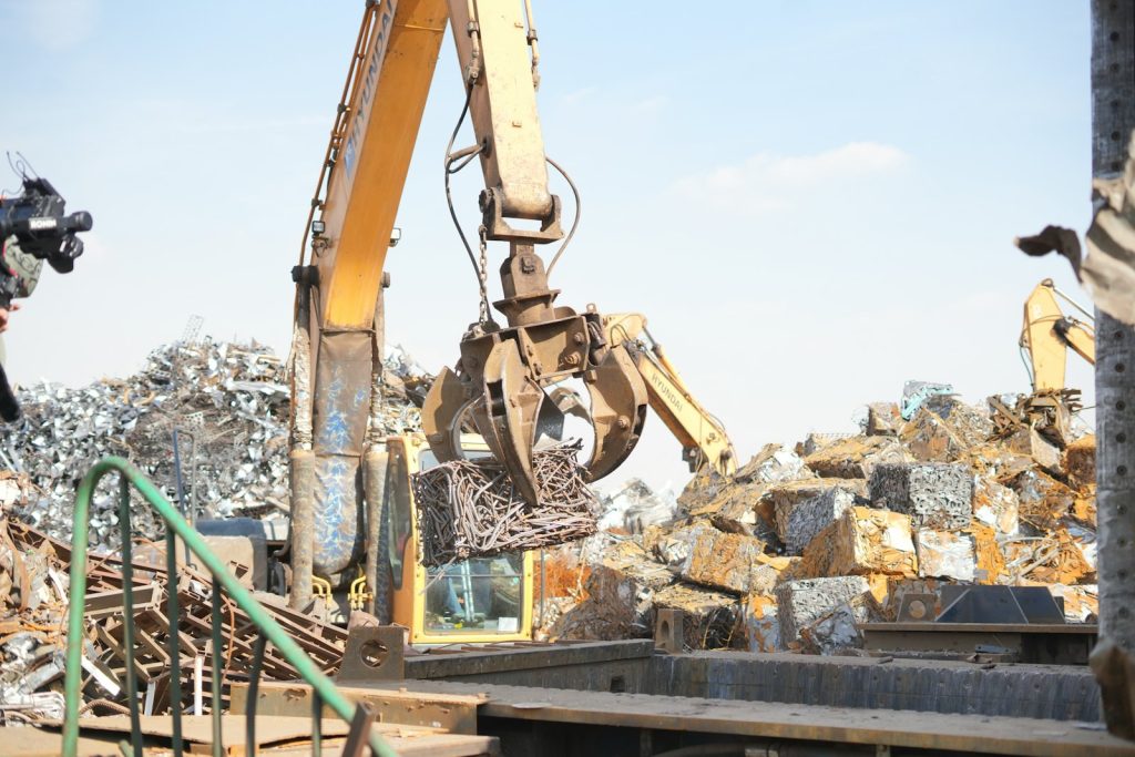 Excavator working on a pile of scrap metal