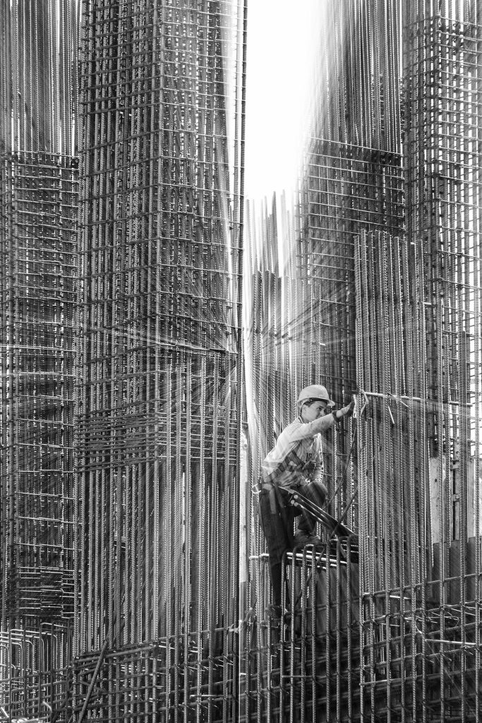 Construction worker fixing steel bars on a building