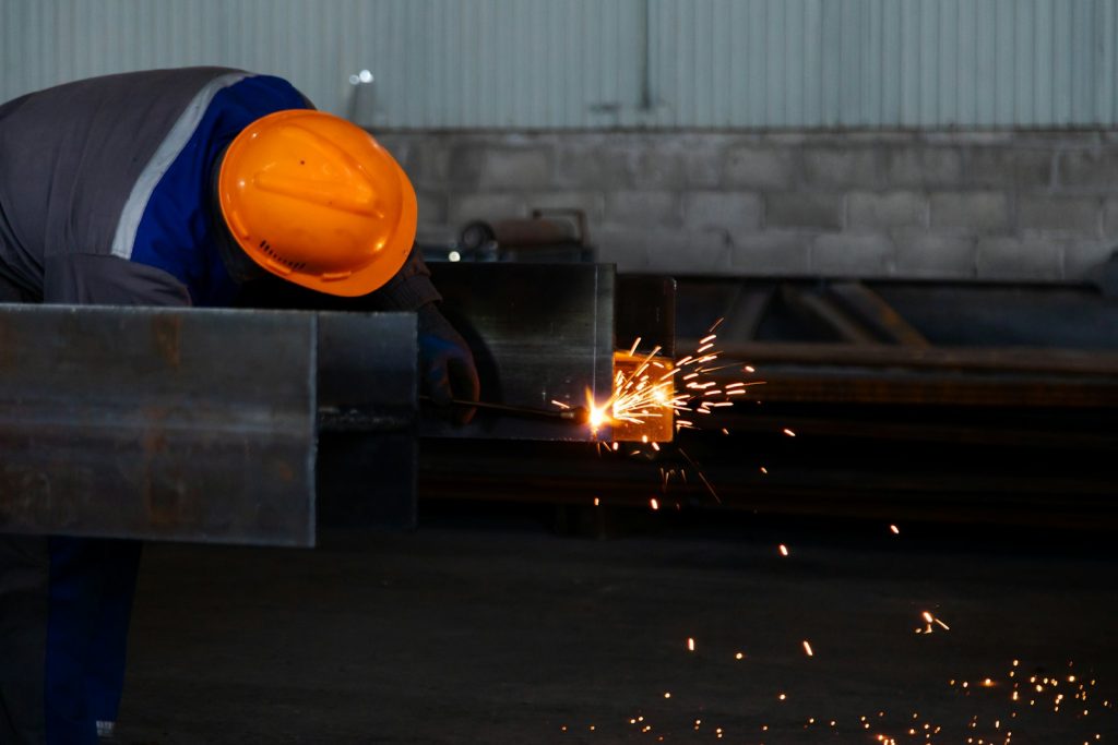 Worker in hard hat working on steel